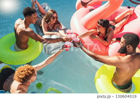 Toast, drinks and friends at a pool party for celebration, holiday and swimming in Los Angeles. Water, happy and group of people with a cheers, alcohol and champagne on a hotel vacation in summer Toast, drinks and friends at a pool party for celebration, holiday and swimming in Los Angeles. Water, happy and group of people with a cheers, alcohol and champagne on a hotel vacation in summer 130604019