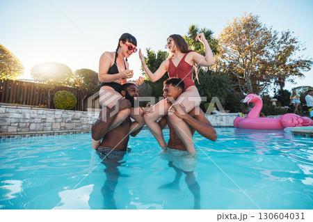 Happy, fun and friends with a game in the pool for summer, swimming and party in Miami. Smile, playful and group of people in the water for vacation, relax and holiday celebration together at a hotel 130604031