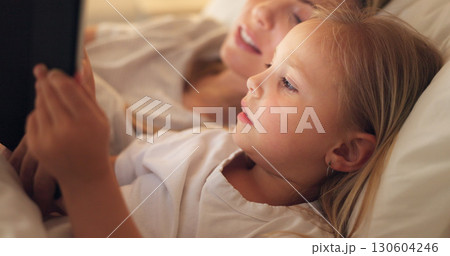 Mom, girl and tablet in bedroom, night and reading with learning, video or movie to relax together in family home. Bedtime story, mother and daughter on bed, cartoon and care with love for bonding Mom, girl and tablet in bedroom, night and reading with learning, video or movie to relax together in family home. Bedtime story, mother and daughter on bed, cartoon and care with love for bonding 130604246