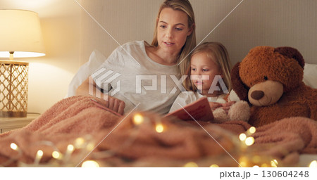 Mom, girl and book on bed, night and reading with learning, knowledge and relax together in family home. Bedtime story, mother and daughter in bedroom, fantasy and together with care, bonding or love 130604248