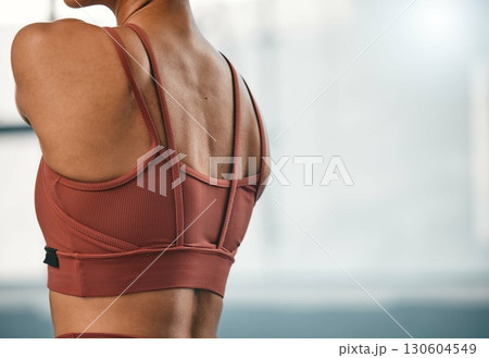 Closeup, shoulder muscle and woman at a gym for training, exercise and cardio against a blurred background. Zoom, back and girl at sports center for fitness, health and performance on mockup space 130604549