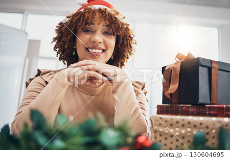 Christmas, gift or portrait and a business black woman posing with a box at an office party or event. December, holiday or present with a female employee sitting next to a giftbox while feeling happy Christmas, gift or portrait and a business black woman posing with a box at an office party or event. December, holiday or present with a female employee sitting next to a giftbox while feeling happy 130604695