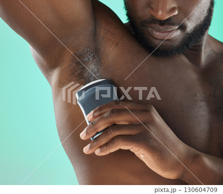 Armpit hygiene and black man with deodorant and self care routine product of people with body zoom in studio. Health, wellness and cosmetic grooming of young person at isolated green background 130604709