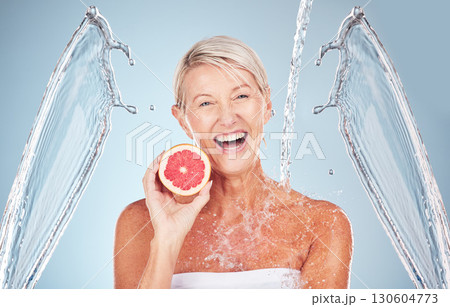 Woman, grapefruit and studio portrait with water splash, happiness and cosmetics for wellness by blue background. Senior model, citrus fruit and vitamin c for health, nutrition and self care process Woman, grapefruit and studio portrait with water splash, happiness and cosmetics for wellness by blue background. Senior model, citrus fruit and vitamin c for health, nutrition and self care process 130604773