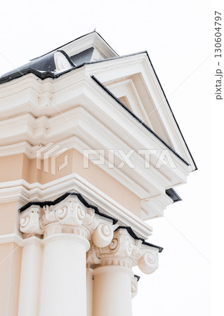 Gate pillar with classical portico is under bright sky. Old classic architecture example 130604797