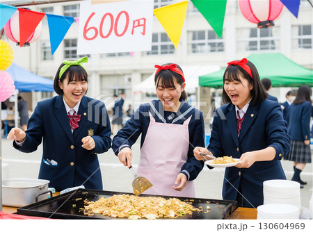文化祭で賑わう高校の校庭、笑顔で焼きそばを作る女子高生たち 130604969
