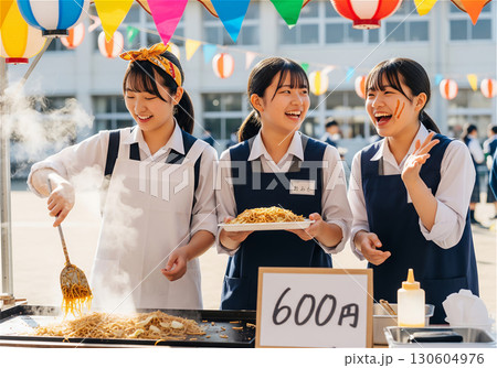 文化祭で賑わう高校の校庭、笑顔で焼きそばを作る女子高生たち 130604976