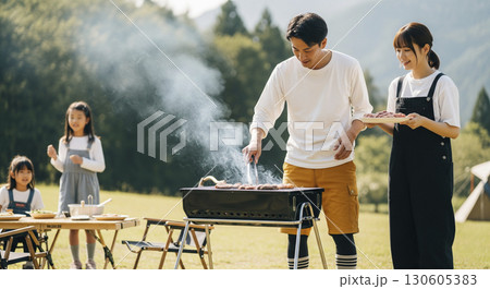 キャンプ場でバーベキューをしている家族 130605383