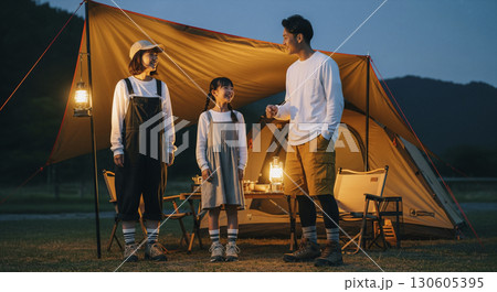 ランタンを灯して夕暮れを楽しむ家族　キャンプシーン 130605395