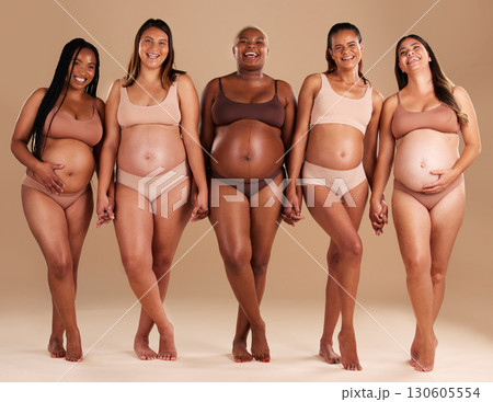 Pregnant, women or portrait of holding hands in support, body empowerment or studio background community. Happy smile, pregnancy or friends underwear for belly growth, diversity pride or mothers day Pregnant, women or portrait of holding hands in support, body empowerment or studio background community. Happy smile, pregnancy or friends underwear for belly growth, diversity pride or mothers day 130605554
