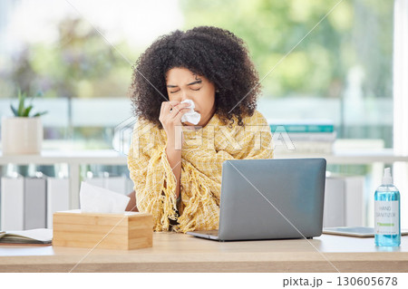 Sick, laptop and blowing nose with a business back woman using a tissue while working in her office. Computer, covid and sneezing with a young female employee wrapped in a blanket while ill at work 130605678