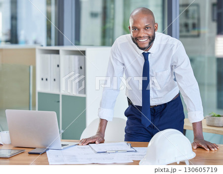 Portrait, black man and architect in office, laptop and achievement with startup, manager or smile. Nigerian male employee, confident leader or engineer with blueprints, happiness or business success 130605719