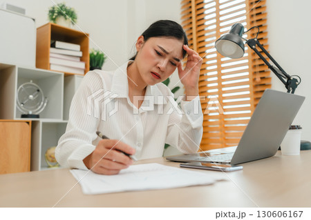 stressed woman working with document and laptop at home office 130606167