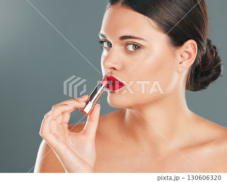 Woman apply lipstick, red on lips and face in portrait with makeup and beauty isolated on studio background. Cosmetic product, skin and skincare glow with wellness, facial and cosmetics shine Woman apply lipstick, red on lips and face in portrait with makeup and beauty isolated on studio background. Cosmetic product, skin and skincare glow with wellness, facial and cosmetics shine 130606320