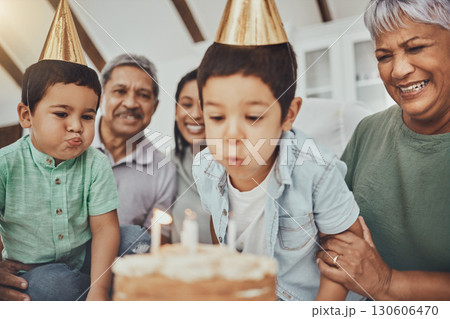 Kids, birthday cake and kid blowing candles at a house at a party with food and celebration. Children, celebrate event and family together in a kitchen with a smile and happiness with parent love Kids, birthday cake and kid blowing candles at a house at a party with food and celebration. Children, celebrate event and family together in a kitchen with a smile and happiness with parent love 130606470