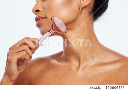 Skincare, beauty and woman with jade roller for her face isolated on a white background in studio. Massage, wellness and cosmetics model with facial care, grooming and relaxing treatment on backdrop 130606553