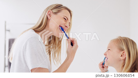 Happy mom, girl child and brushing teeth in bathroom, learning and care with foam for wellness in family house. Toothbrush, mother and daughter with toothpaste, teaching or cleaning mouth for health Happy mom, girl child and brushing teeth in bathroom, learning and care with foam for wellness in family house. Toothbrush, mother and daughter with toothpaste, teaching or cleaning mouth for health 130606854