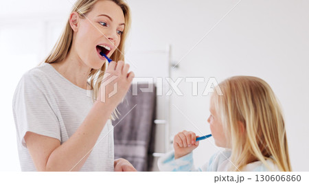 Mom, girl child and brushing teeth in bathroom, learning and learning with foam for wellness in family house. Toothbrush, mother and daughter with toothpaste, teaching and cleaning mouth for health Mom, girl child and brushing teeth in bathroom, learning and learning with foam for wellness in family house. Toothbrush, mother and daughter with toothpaste, teaching and cleaning mouth for health 130606860