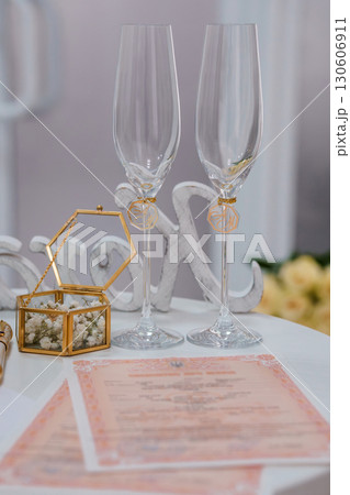 Elegant Wedding Champagne Glasses Toast with Golden Details, Peach Decor, Rings, Invitation, Romantic Celebration Still Life. Elegant Wedding Champagne Glasses Toast with Golden Details, Peach Decor, Rings, Invitation, Romantic Celebration Still Life. 130606911