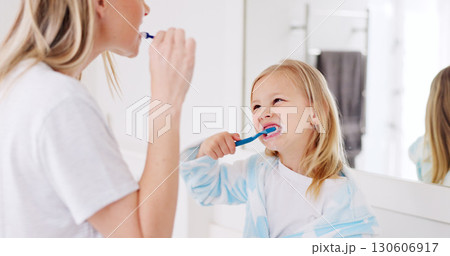 Mom, girl kid and brushing teeth in bathroom, learning and support with foam for wellness in family house. Toothbrush, mother and daughter with toothpaste, teaching and health with cleaning mouth Mom, girl kid and brushing teeth in bathroom, learning and support with foam for wellness in family house. Toothbrush, mother and daughter with toothpaste, teaching and health with cleaning mouth 130606917