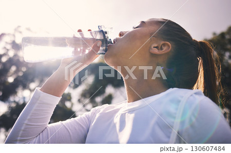 Drinking water, fitness and running with a sports woman outdoor for a cardio or endurance workout. Training, exercise and wellness with a female athlete taking a drink for hydration on a break Drinking water, fitness and running with a sports woman outdoor for a cardio or endurance workout. Training, exercise and wellness with a female athlete taking a drink for hydration on a break 130607484
