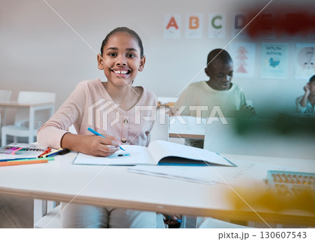 Education, class and portrait of child with smile in classroom learning reading, writing and math in Montessori school. Books, students and happy girl at desk with notebook studying for future exam. 130607543