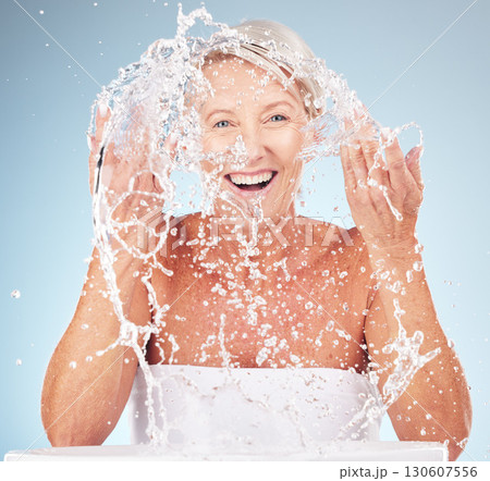Shower, face and old woman with smile and water splash, clean skin and antiaging beauty, elderly model isolated on studio background. Senior skincare, cosmetics and facial portrait, happy and hygiene 130607556
