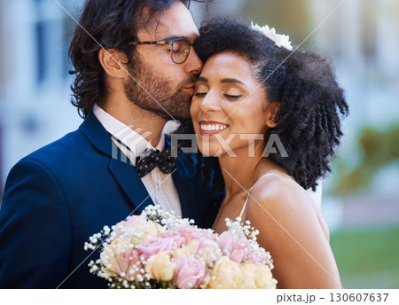 Care, kiss and couple at wedding happy with romantic outdoor marriage event celebration with flowers. Partnership, commitment and trust embrace of interracial bride and groom with excited smile. 130607637