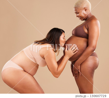 Pregnant woman friends, studio and kiss stomach with underwear, smile and together for support by backdrop. Happy women, pregnancy and solidarity for wellness, care and healthy abdomen by background Pregnant woman friends, studio and kiss stomach with underwear, smile and together for support by backdrop. Happy women, pregnancy and solidarity for wellness, care and healthy abdomen by background 130607729