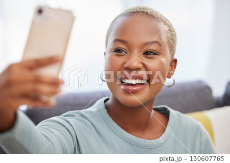 Black woman, influencer and smile for selfie, social media or profile picture relaxing on living room sofa at home. African American female vlogger smiling in happiness for online post in the lounge 130607765