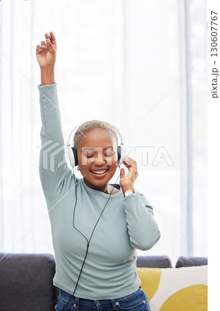 Music, dance and happy black woman listening to African radio, audio podcast or digital playlist song. Wellness girl, dancing energy and excited dancer hearing, enjoy and streaming sound at home 130607767