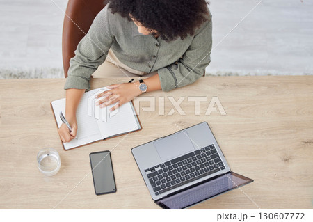 Laptop, writing and notebook with a business black woman at work on a schedule in her office from above. Computer, research and overhead with a female employee planning while working at a desk 130607772