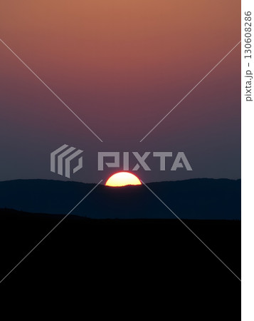 Majestic Sunset Illuminating the Mountain Silhouette with Vibrant, Warm Hues 130608286