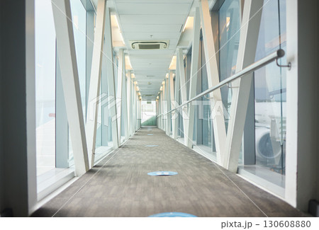 Airport backgrounds, terminal hallway and corridor for traveling, journey and covid transport regulations. Empty walkway for airplane flight, immigration and interior design tunnel space for walking Airport backgrounds, terminal hallway and corridor for traveling, journey and covid transport regulations. Empty walkway for airplane flight, immigration and interior design tunnel space for walking 130608880