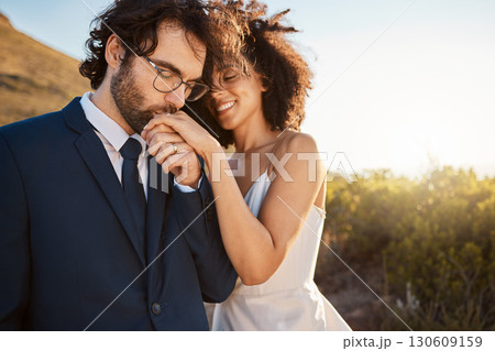 Love, happy and wedding with couple in nature for celebration, happiness and romance. Sunset, hug and affectionate with husband and wife in embrace at countryside for kiss, marriage or smile together 130609159