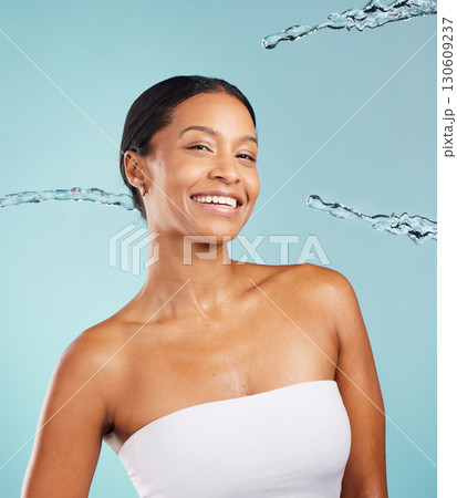 Happy black woman, portrait and water splash in studio for cleaning cosmetics on blue background. Face of female model, shower drops and beauty for healthy skincare, wellness and facial aesthetics Happy black woman, portrait and water splash in studio for cleaning cosmetics on blue background. Face of female model, shower drops and beauty for healthy skincare, wellness and facial aesthetics 130609237