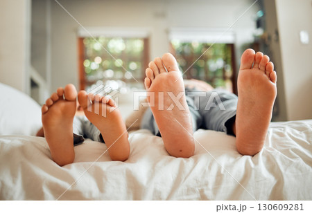 Feet, family and dad sleeping on a bed with child in a bedroom at a home or house bonding together. Resting, break and parent with kid barefoot bonding and relaxing together spending time Feet, family and dad sleeping on a bed with child in a bedroom at a home or house bonding together. Resting, break and parent with kid barefoot bonding and relaxing together spending time 130609281