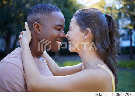 Fun, love and interracial couple at park for date, summer holiday and outdoor wellness with hug, care and nose game. Happy, young and diversity people in green garden, nature and excited together 130609297