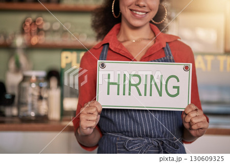 Small business, hands or black woman with a hiring sign for job vacancy offer in cafe or coffee shop. Recruitment, marketing or happy entrepreneur smiles with an onborading message in store 130609325