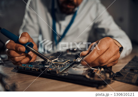 Man hands, it or soldering motherboard in engineering workshop for night database fixing. Zoom, technician or circuit board tools in repair, maintenance or upgrade in information technology industry 130610121
