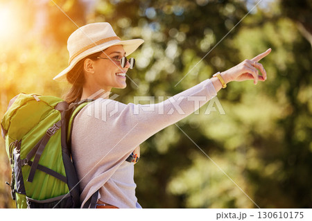 Happy woman, backpack or pointing in nature travel, sightseeing park or bird watching adventure in trees forest. Smile, tourist and direction hand in hiking location, Canada woods or interface search 130610175