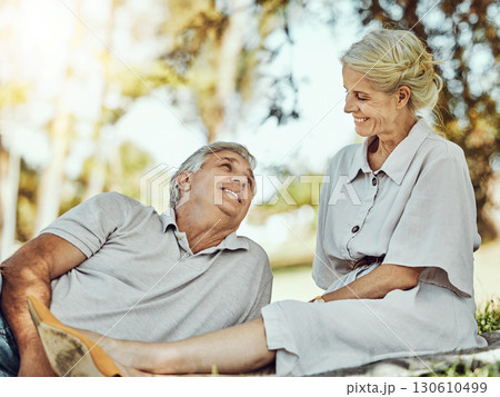 Retirement, love and picnic with a mature couple outdoor in nature to relax on a green field of grass together. Happy, smile and date with a senior man and woman bonding outside for romance 130610499