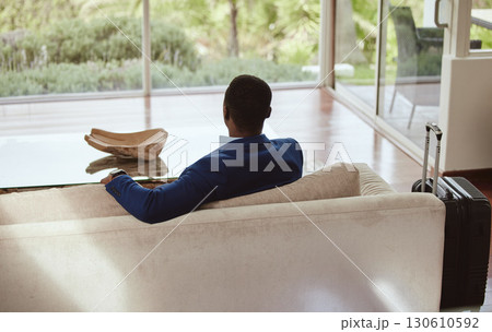 Thinking, immigration and vision of businessman on a couch or sofa in a hotel sitting looking at a window. Rear view, travel and back of professional corporate worker waiting in lounge or living room Thinking, immigration and vision of businessman on a couch or sofa in a hotel sitting looking at a window. Rear view, travel and back of professional corporate worker waiting in lounge or living room 130610592