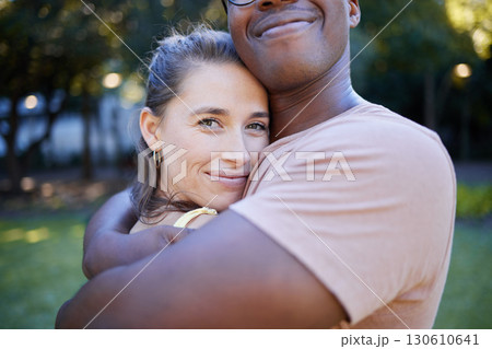 Interracial relationship hug, park and woman with smile, care and love with black man, reunion and happiness. Multicultural embrace, happy couple and diversity on nature adventure, bonding and spring 130610641