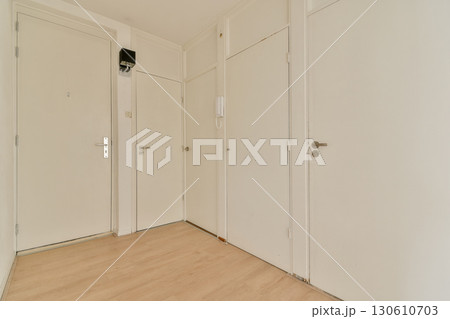 A bright and minimalist hallway featuring white walls and wooden flooring, offering a modern and spacious feel. Ideal for showcasing minimalist design. 130610703