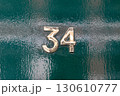 Brass number thirty four on glossy green door 130610777