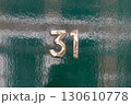 Brass number thirty one on glossy green door 130610778