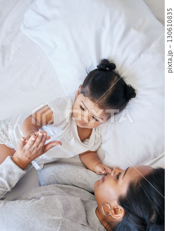Baby, mother care and girl in a bedroom bed with parent support and love with happiness. Morning, house and bonding together of a mom and child holding hands feeling happy from motherhood in a home 130610835
