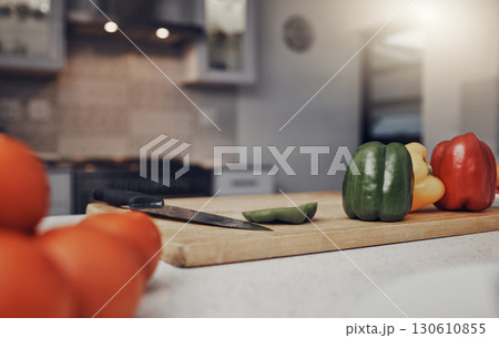 Kitchen, table and cutting board with vegetables of colorful peppers for healthy meal preparation at home. Food, cooking or nutrition of organic grown consumables on counter for diet plan or vitamins Kitchen, table and cutting board with vegetables of colorful peppers for healthy meal preparation at home. Food, cooking or nutrition of organic grown consumables on counter for diet plan or vitamins 130610855