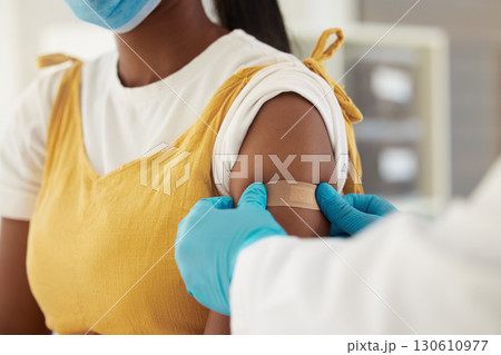 Vaccine, covid and a plaster on the arm of a black woman in a hospital for healthcare. Nurse, doctor and medical with a medicine professional in a clinic to apply a bandage after corona vaccination Vaccine, covid and a plaster on the arm of a black woman in a hospital for healthcare. Nurse, doctor and medical with a medicine professional in a clinic to apply a bandage after corona vaccination 130610977